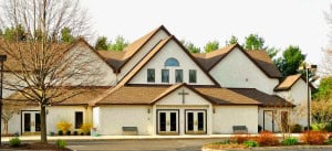 Modern Windsor Chapel building with cross, surrounded by trees and landscaping, welcoming church community.